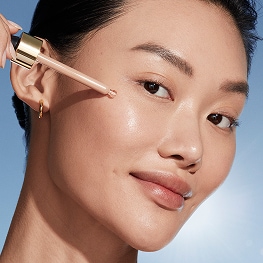 photo of woman with passport makeup applying futurist skintint serum