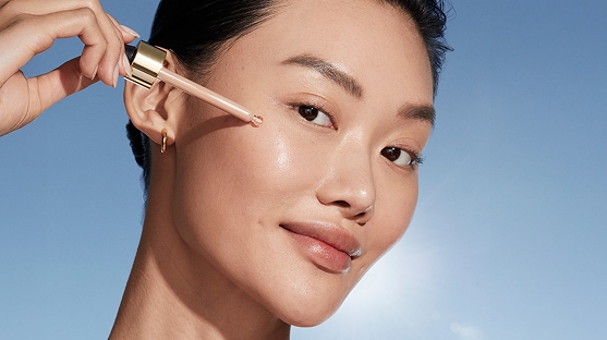 photo of woman with passport makeup applying futurist skintint serum