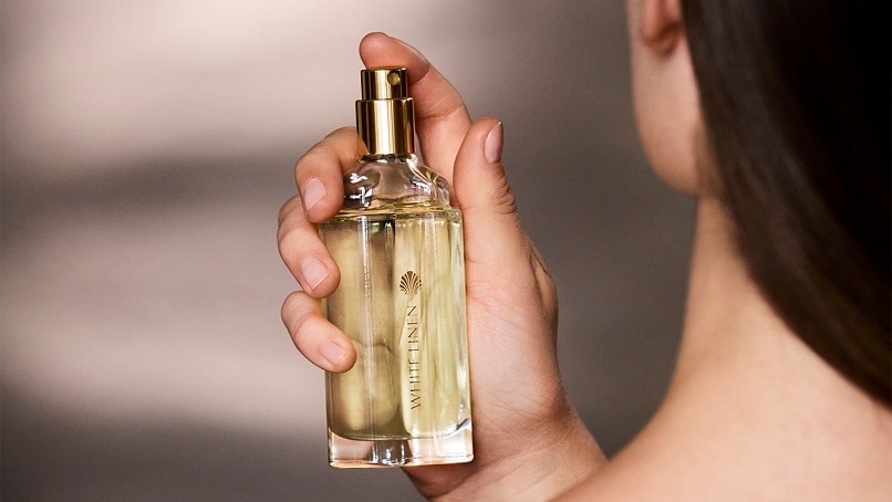 photo of woman applying long lasting fragrance from estee lauder