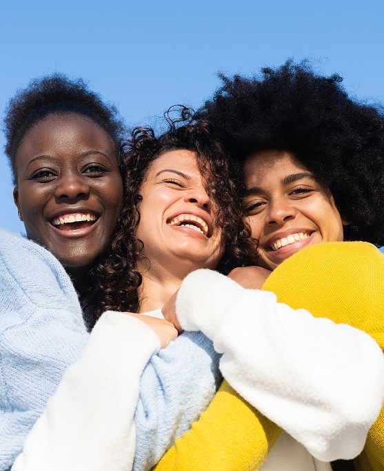 photo of 3 women hugging power of touch for longevity benefits